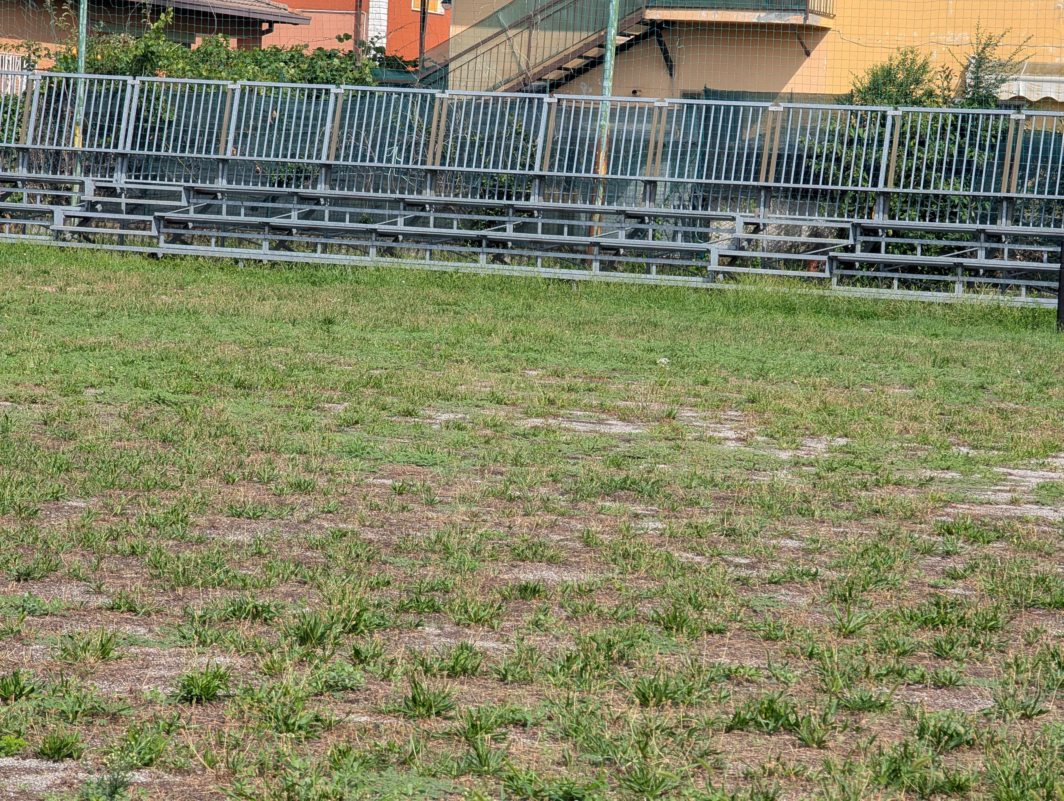 La tribuna vuota e il terreno del campo sportivo