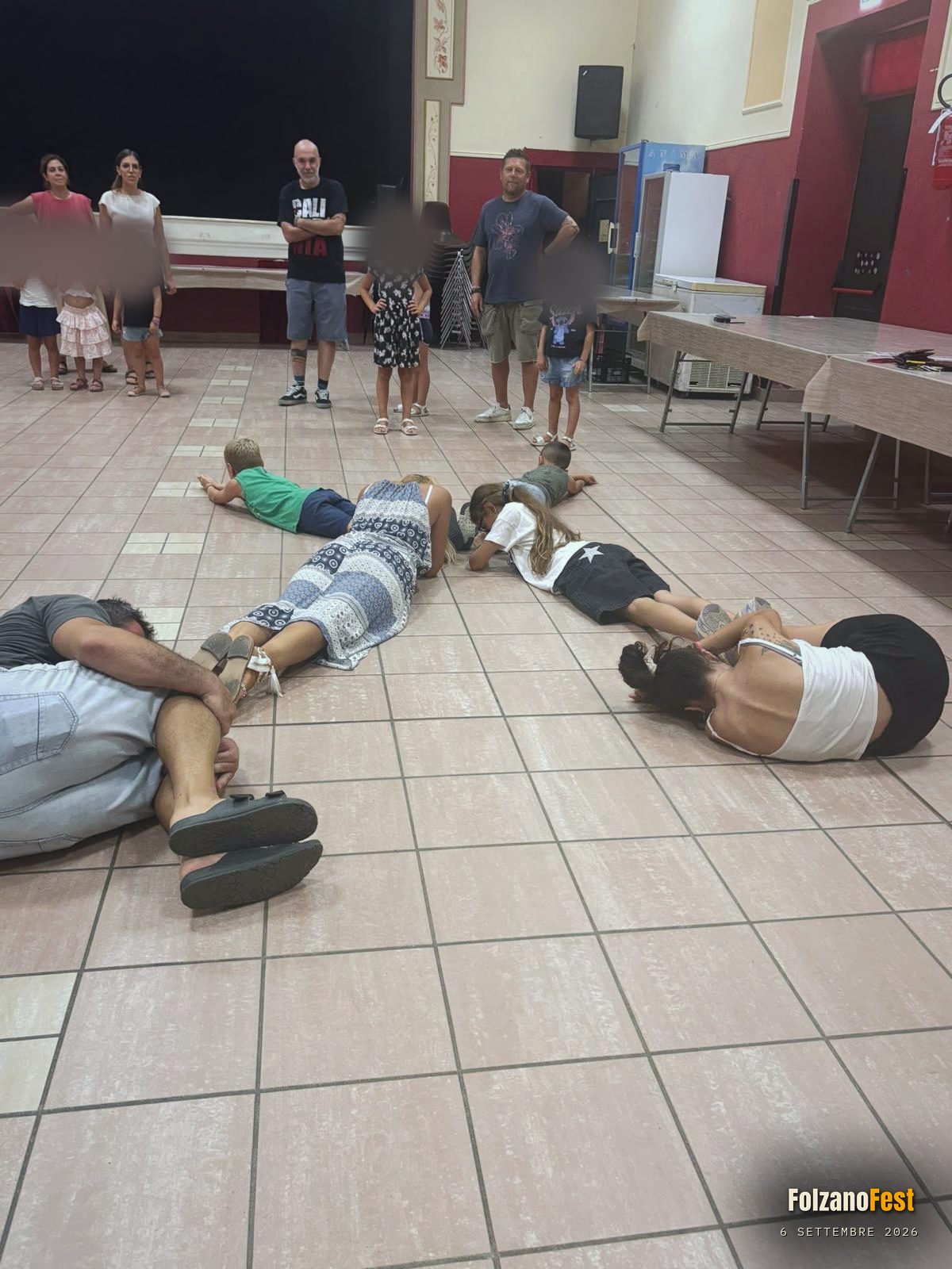 Un trenino disteso a terra, con gli altri a guardare