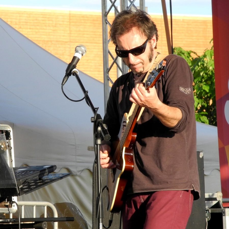 Lello Garelli alla chitarra su un palco all’aperto
