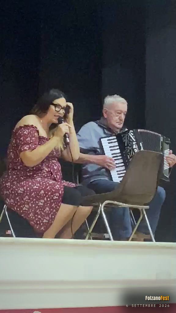 Stefania Martin al microfono e Franco Bosio alla fisarmonica, seduti sul palco del salone