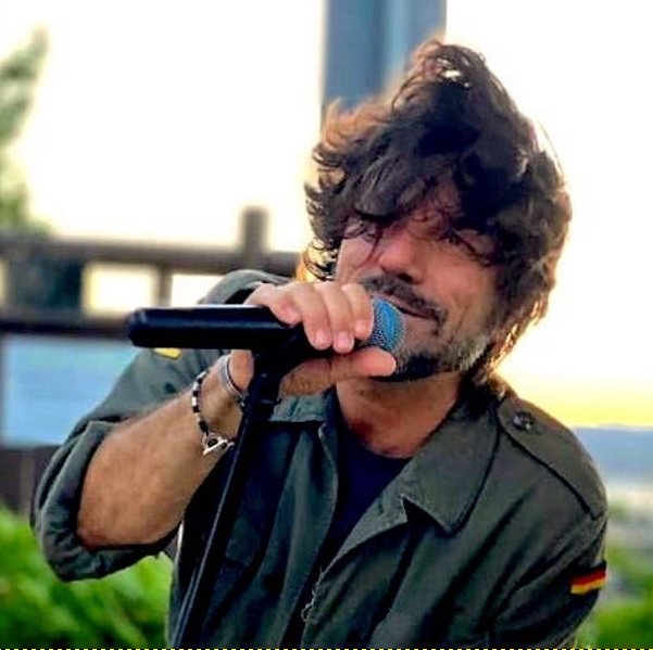 Roberto Guolo che canta all'aperto, al tramonto