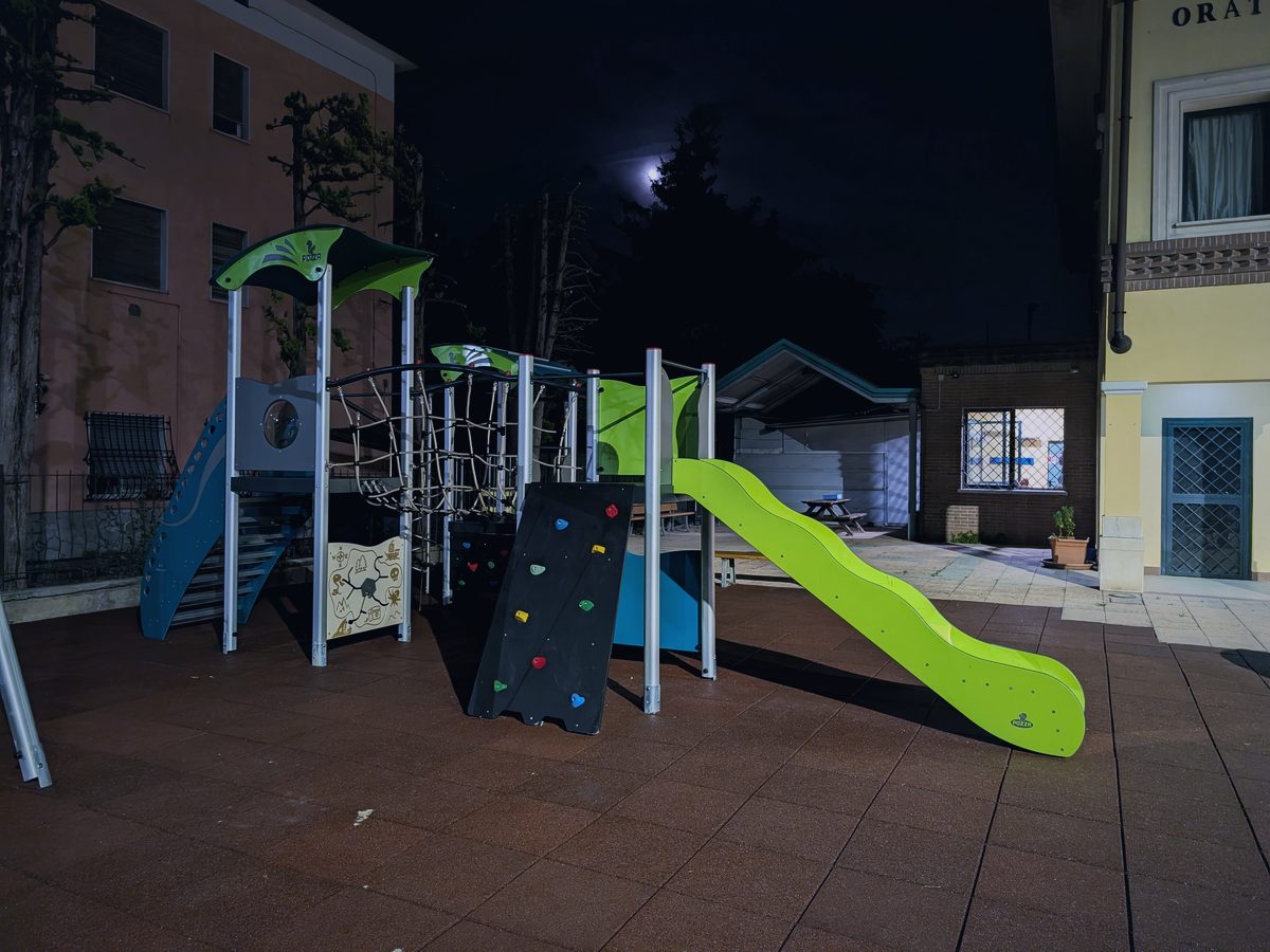 La struttura dello spazio giochi vista da vicino, con la rete, la parete da arrampicata e lo scivolo