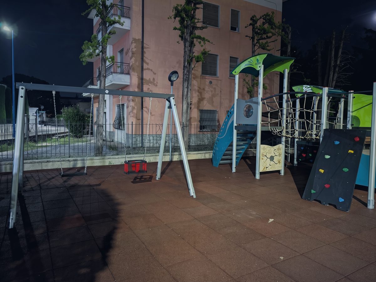 Le altalene dello spazio giochi, con il seggiolino per i più piccoli, e la parete da arrampicata sulla destra