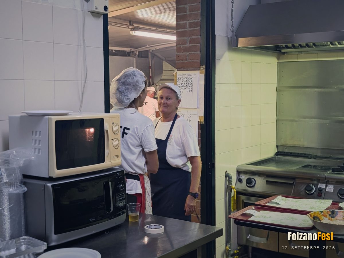 Due volontari parlano, vicino ai fornelli