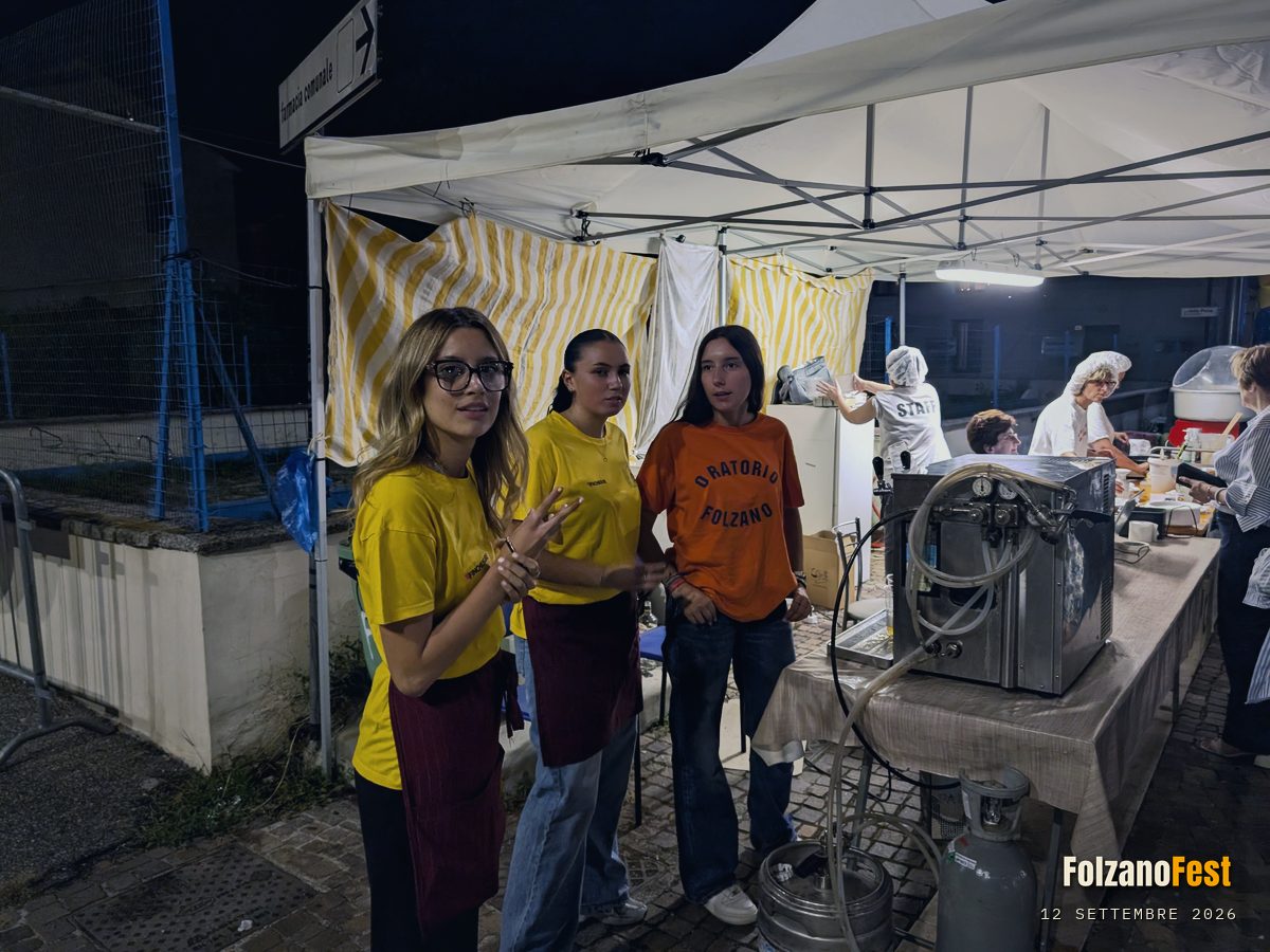 Tre volontarie, davanti al gazebo delle bevande