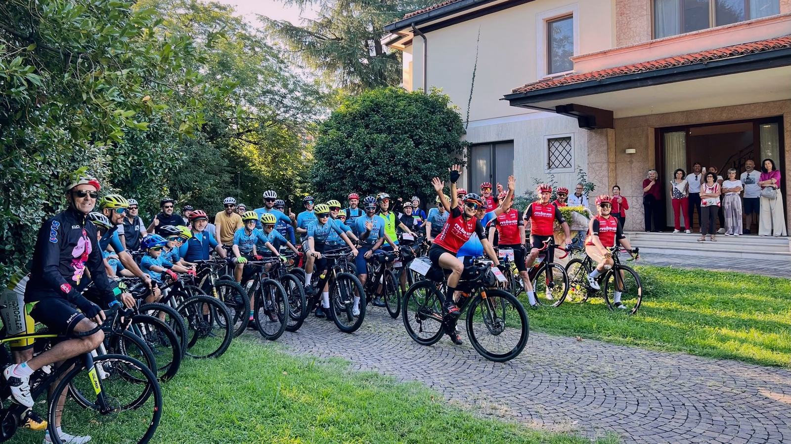 Un gruppo di una trentina di ciclisti in posa prima della partenza, Simona Casana al centro con il braccio alzato