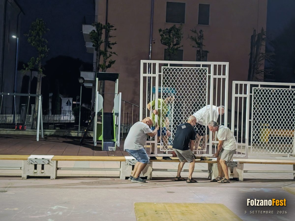 Volontari montano le recinzioni in piazza la sera prima della festa