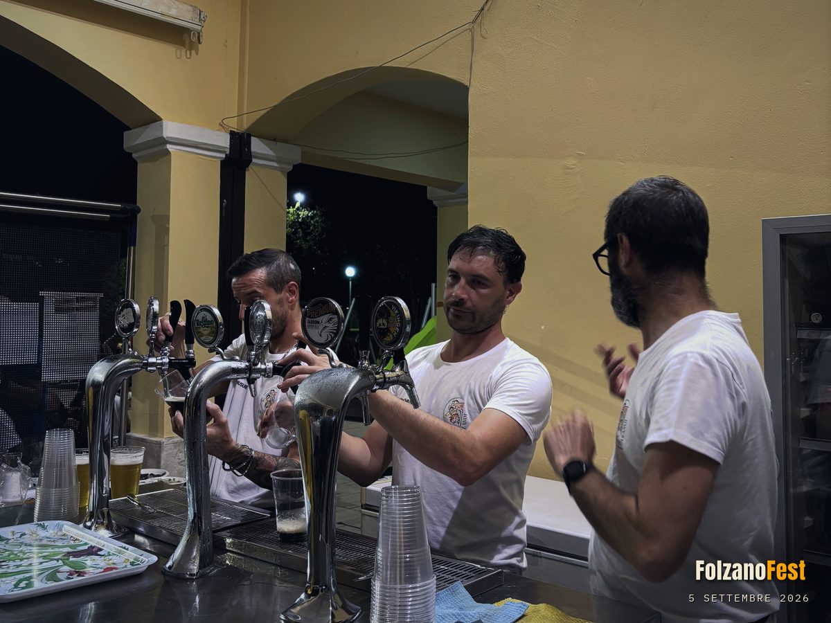 Tre volontari alla spina del bar, sotto il portico dell'oratorio